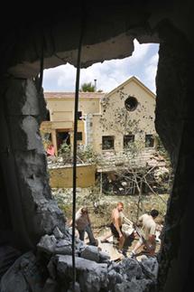 Israelis look at a damaged house