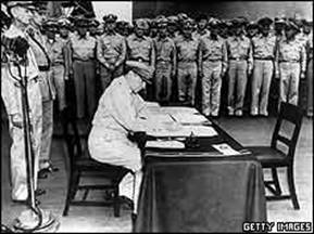 General MacArthur signing document at table with soldiers watching